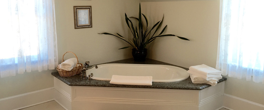 The bathroom has an oversized soaking tub, vanity, and spacious glass enclosed shower